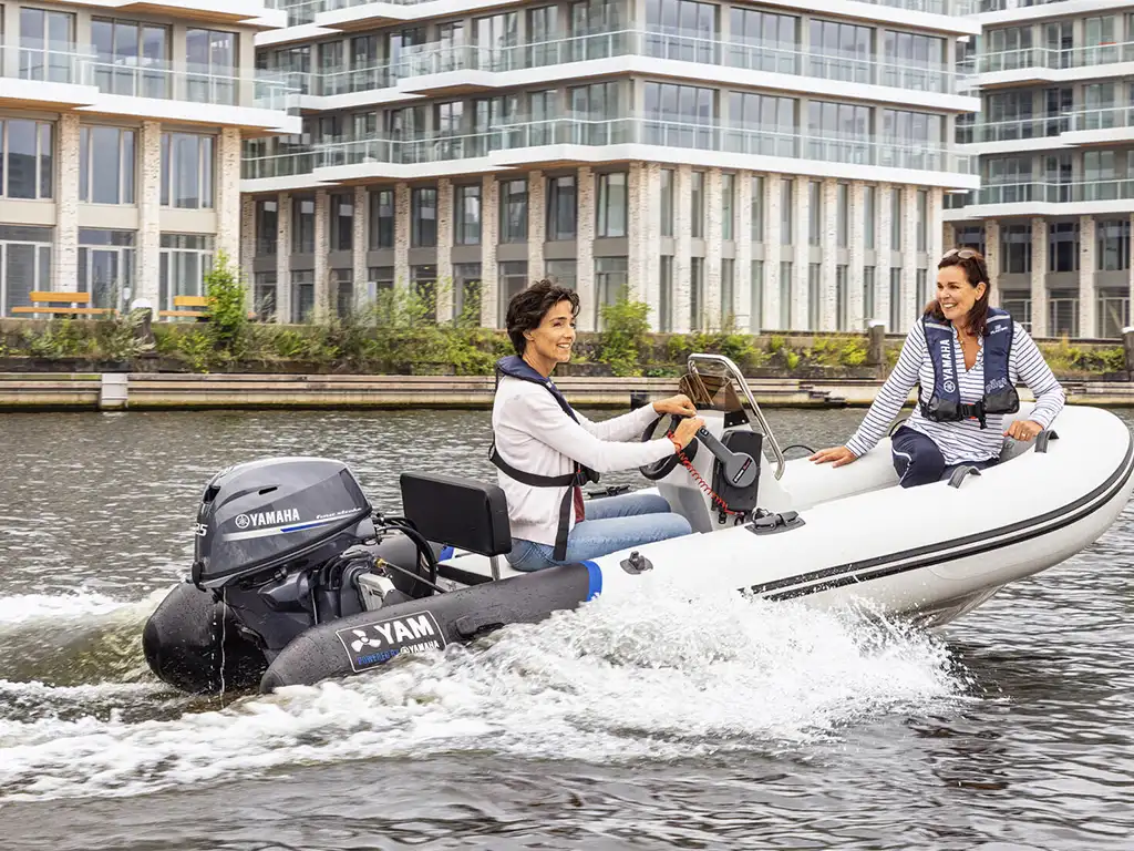 Two people on a Yamaha inflatable with Yamaha Outboard on the water.
